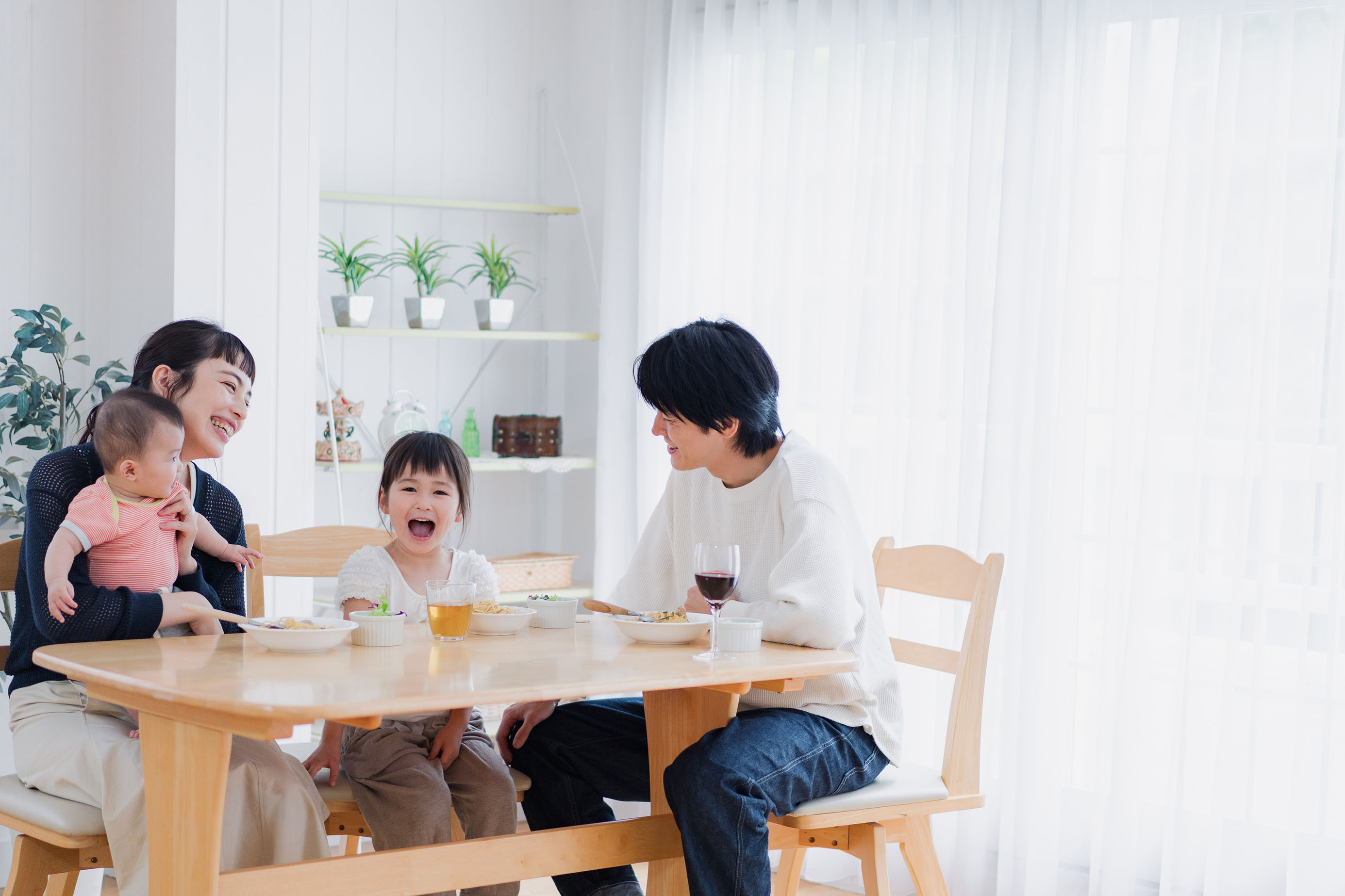 楽しそうに事務員の話を聞く子供連れの夫婦